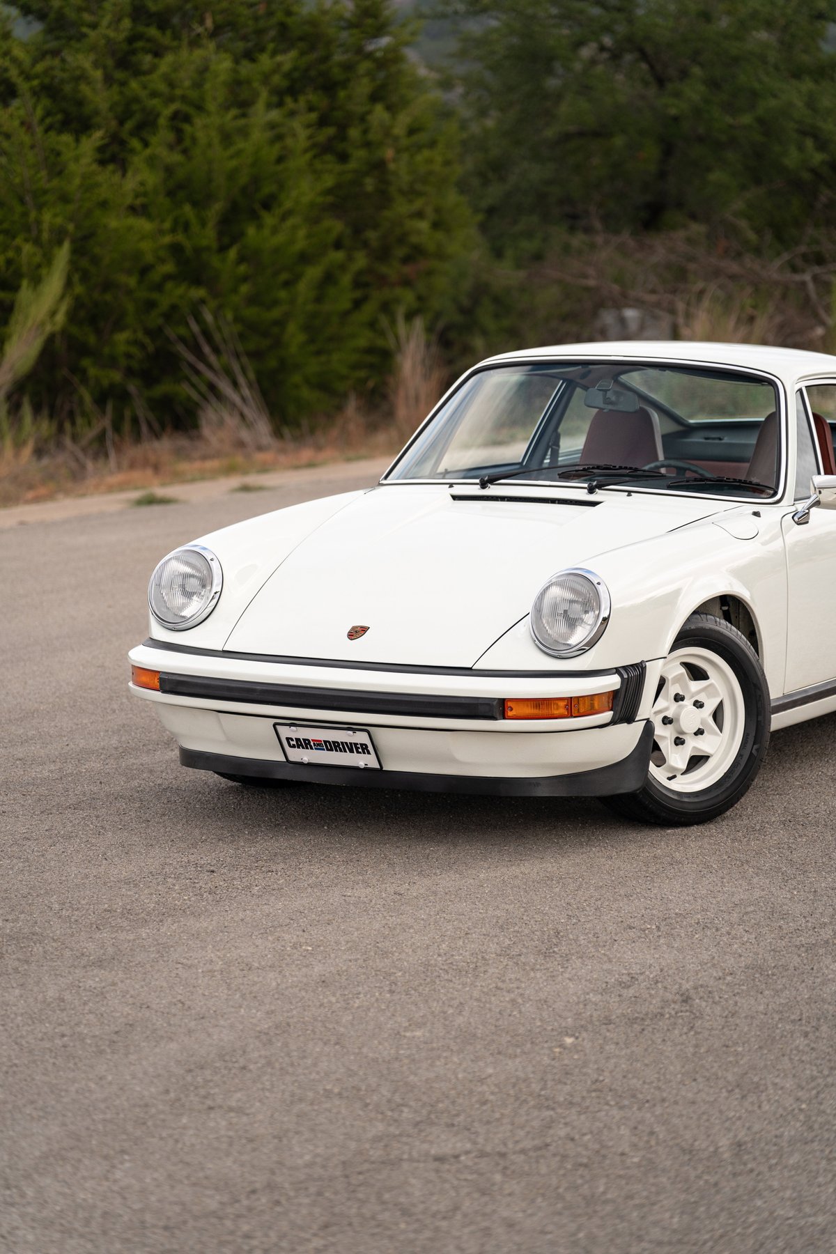 1974 Porsche 911 coupe in white, with unique five-star alloy rims and tan interior.