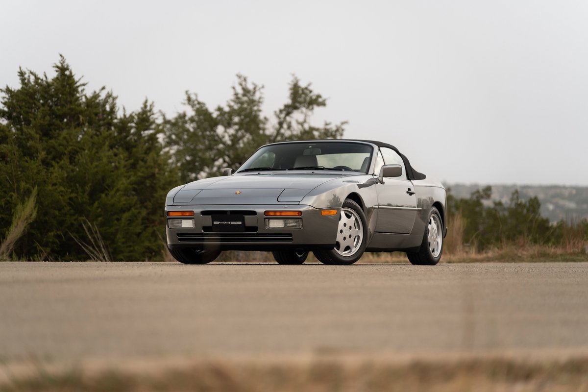 Front 3/4 view of a grey 1990 Porsche 944 S2 Cabriolet with factory rims.