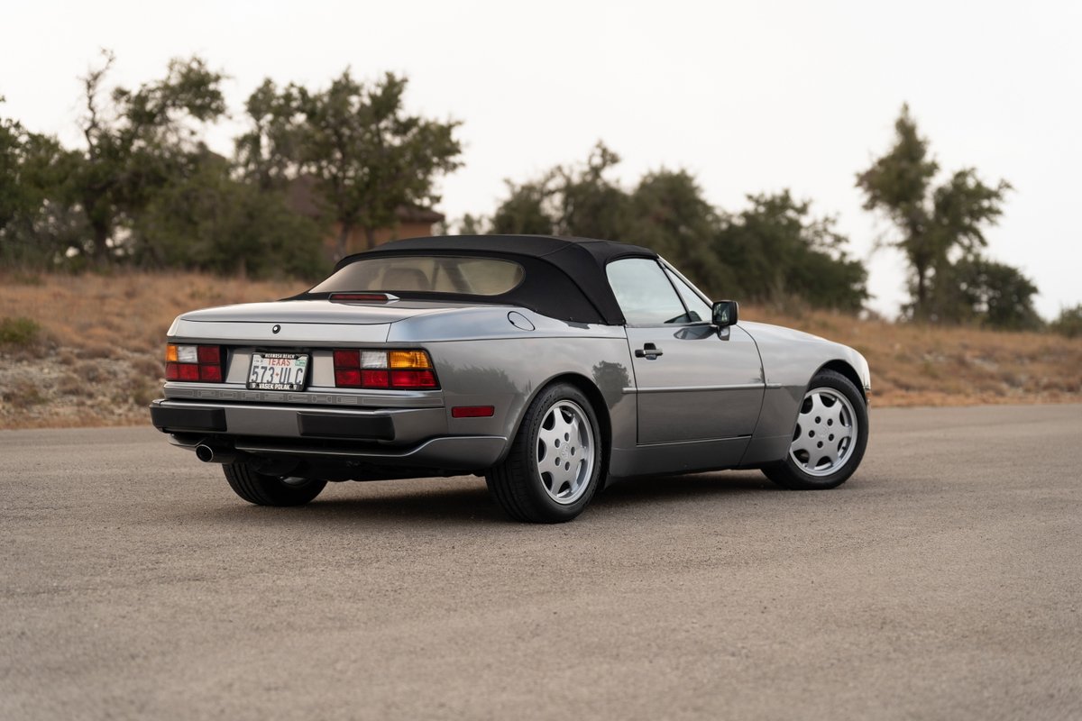Rear quarter view of a titanium metallic 1990 Porsche 944 S2 Cabriolet with turbines wheels.
