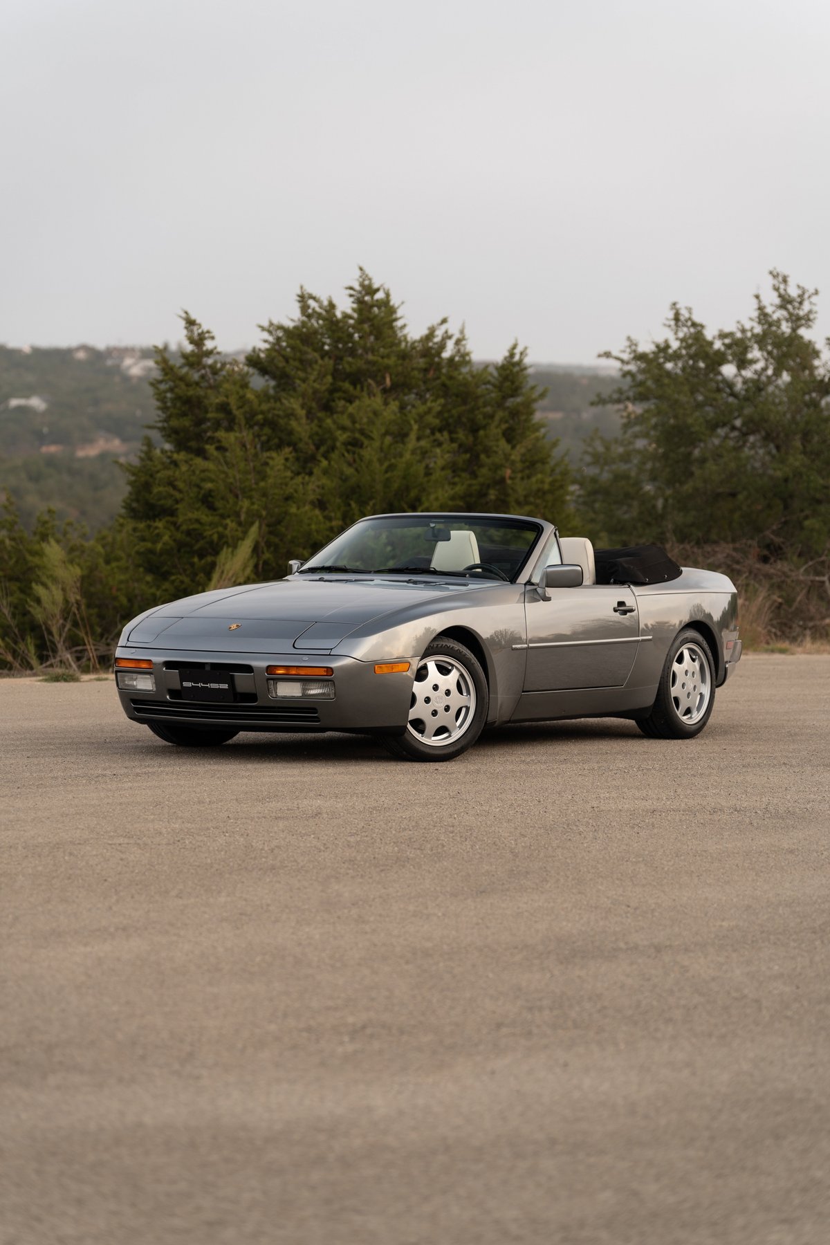 A 1990 Porsche 944 S2 Cabriolet in Titanium Metallic, with cup-style rims.