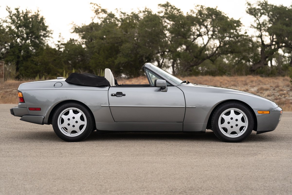 Silver 1990 Porsche 944 S2 Cabriolet with teardrop rims and black convertible top.