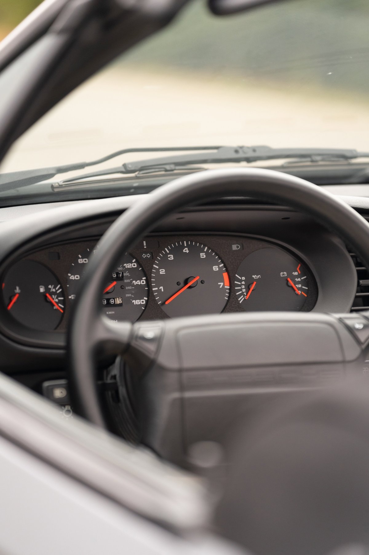 Interior of a 1990 Porsche 944 S2 Cabriolet in Titanium Metallic, featuring the instrument cluster and steering wheel.