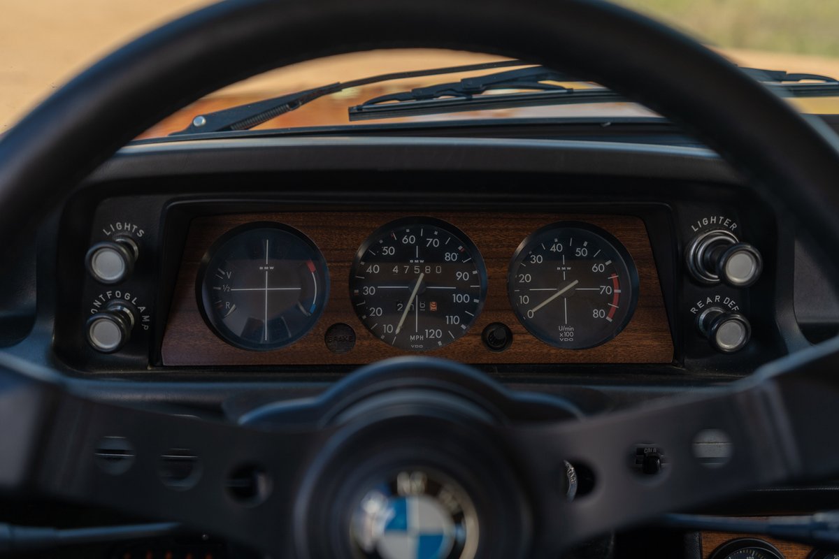 1976 BMW 2002 Inka Orange dashboard, wood trim, and gauges.