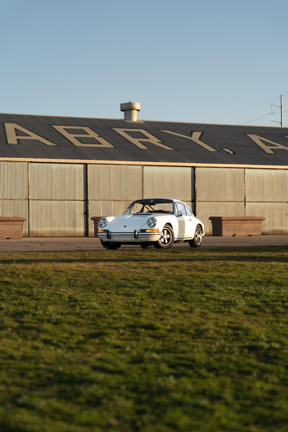 1970 Porsche 911T coupe in Light Ivory with chrome trim and Fuchs wheels.