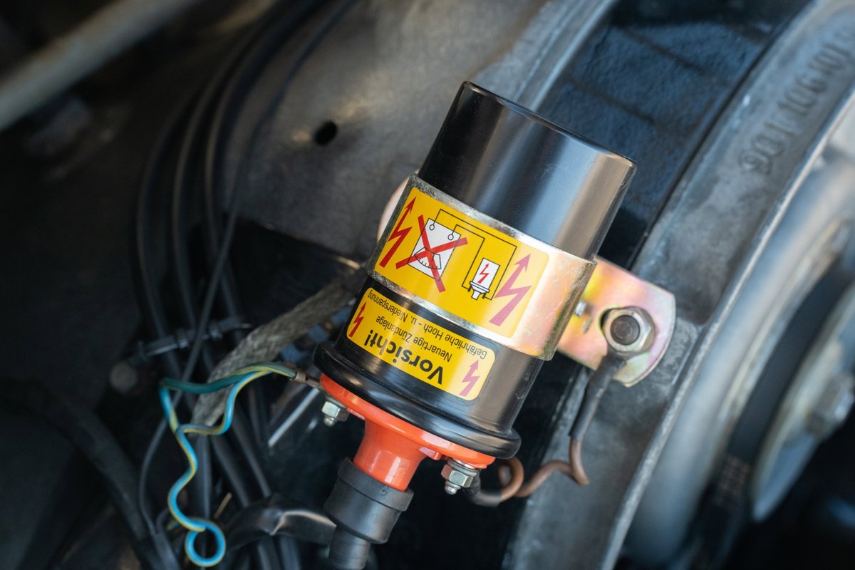 1970 Porsche 911T coupe ignition coil with warning labels and wiring.