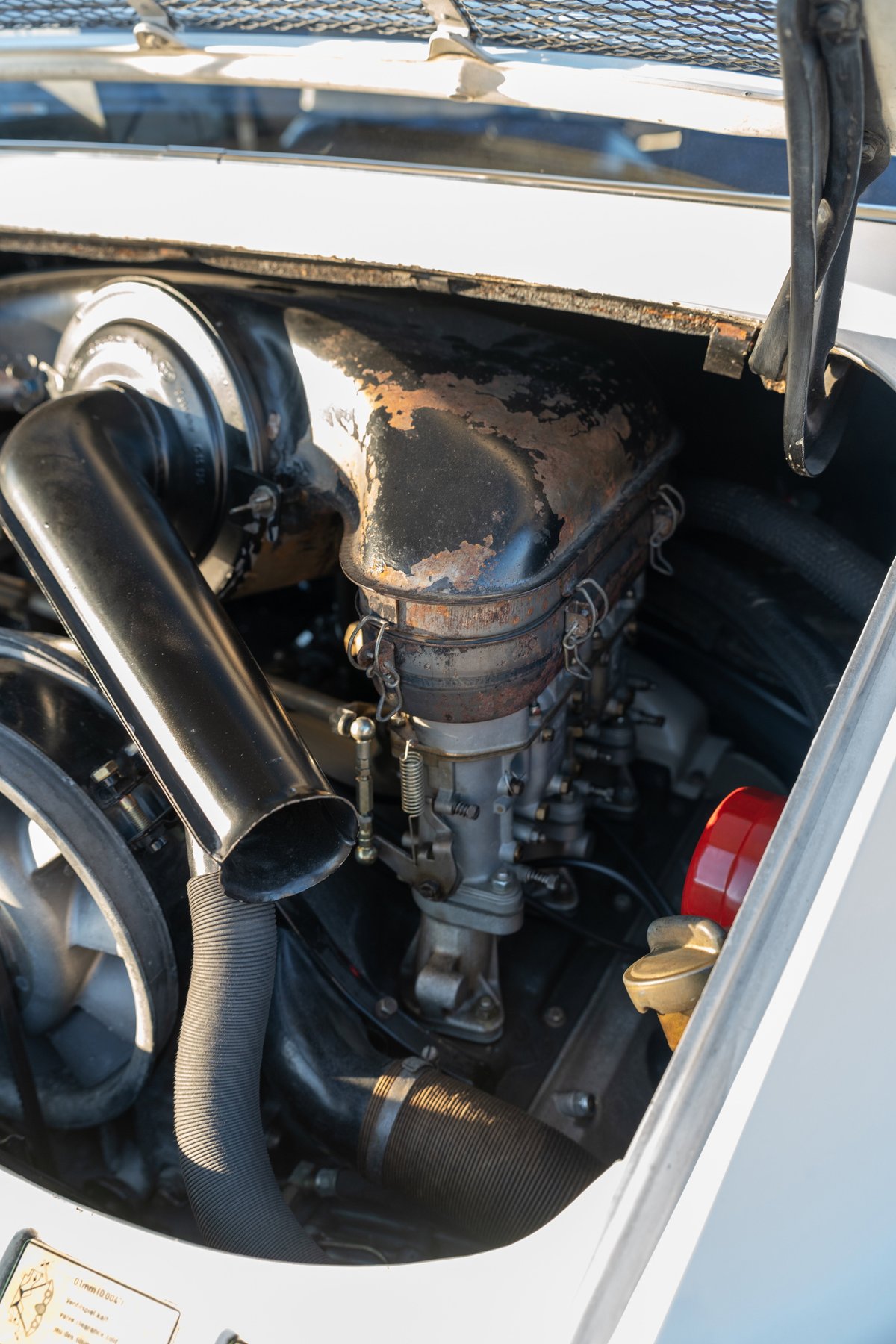 1970 Porsche 911T engine bay in light ivory, showing carburetor and intake.