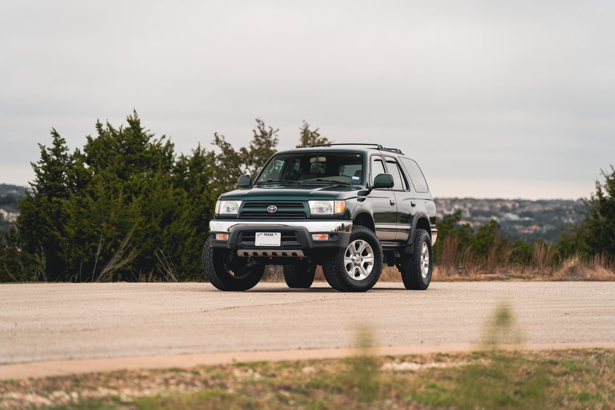 Imperial Jade Mica 2000 Toyota 4Runner with chrome trim and alloy rims on a paved road.