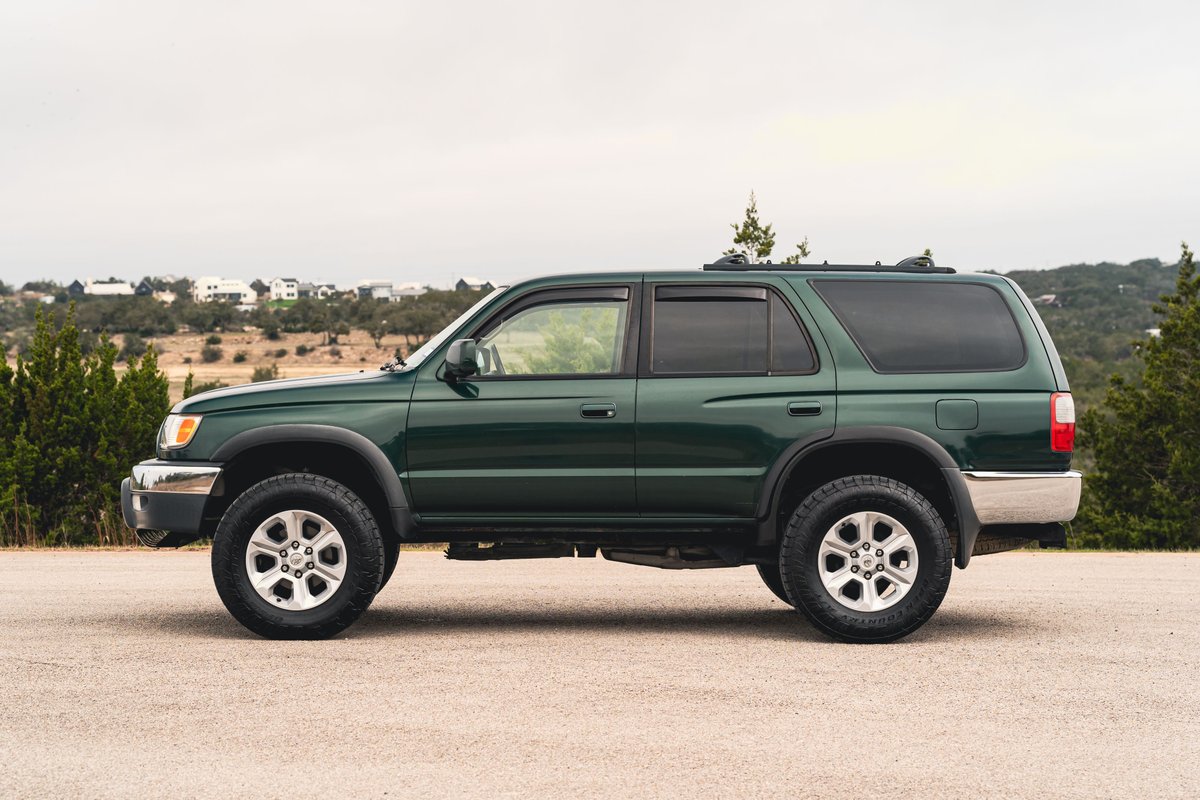 Green 2000 Toyota 4Runner with silver rims, dark tinted windows, and chrome trim accents.