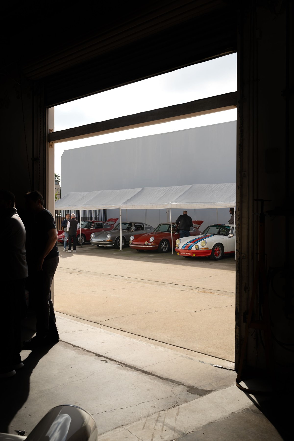 Porsche 911 with Martini Racing livery, white, red, and blue stripes, classic rims.