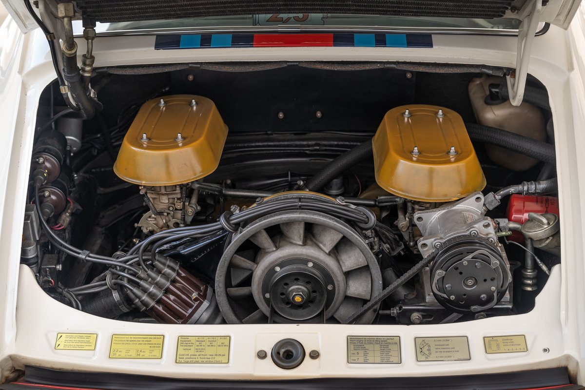 Porsche 911 engine bay with twin Weber carburetors and gold airbox lids.