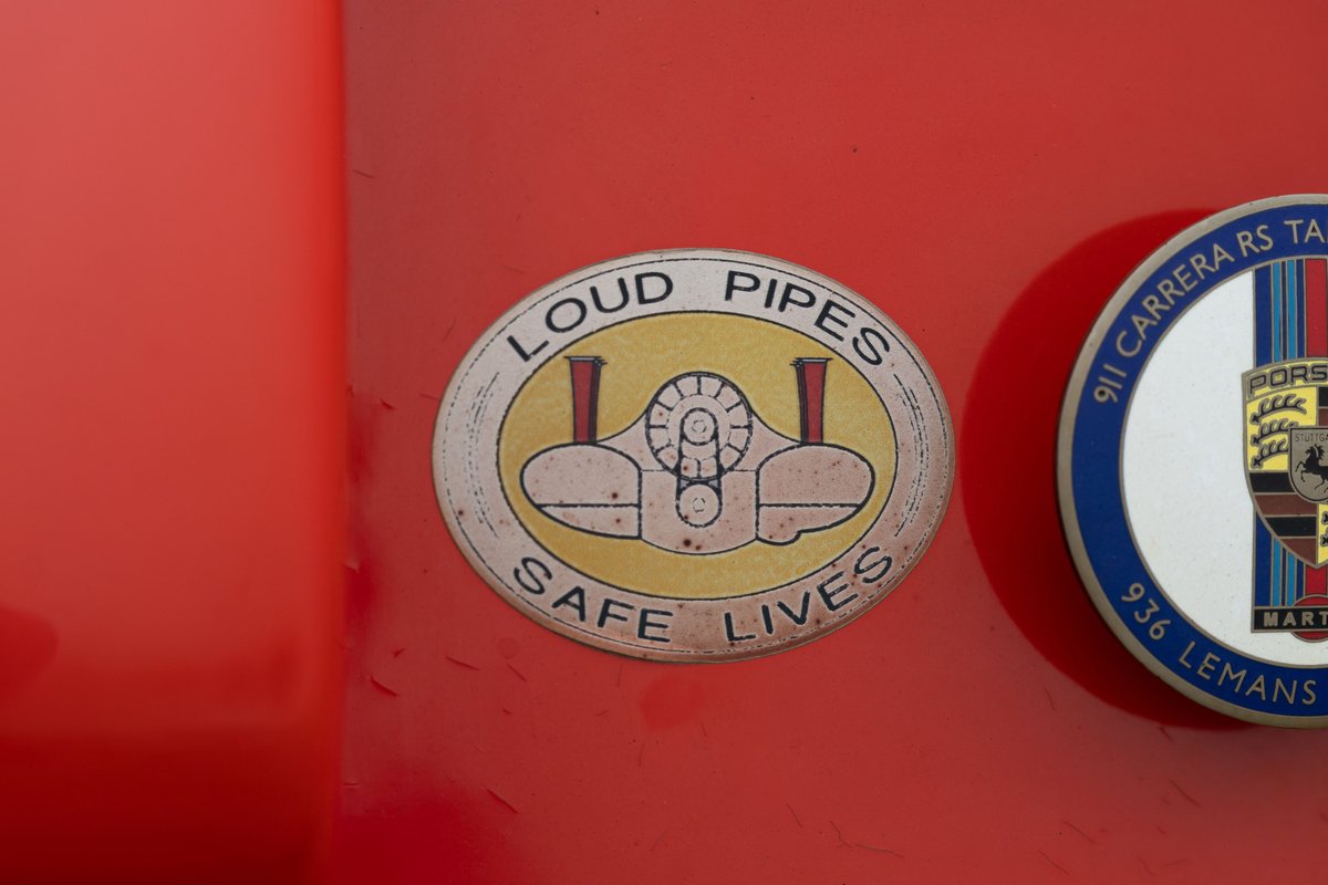 Red Porsche with "Loud Pipes Safe Lives" sticker and 936 Lemans badge.
