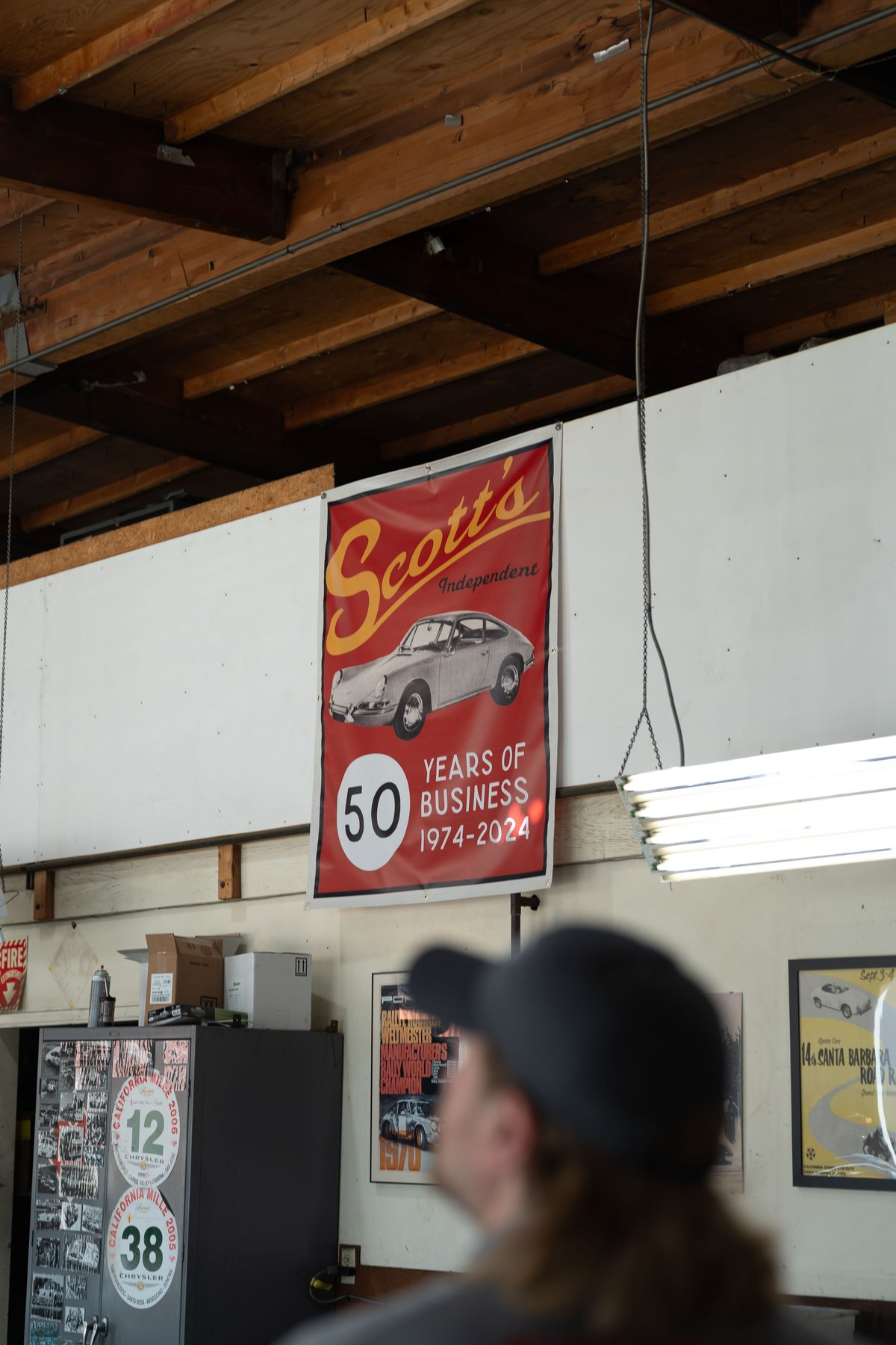 Scott's Independent 50th anniversary banner features a silver Porsche 911 coupe with classic chrome rims.