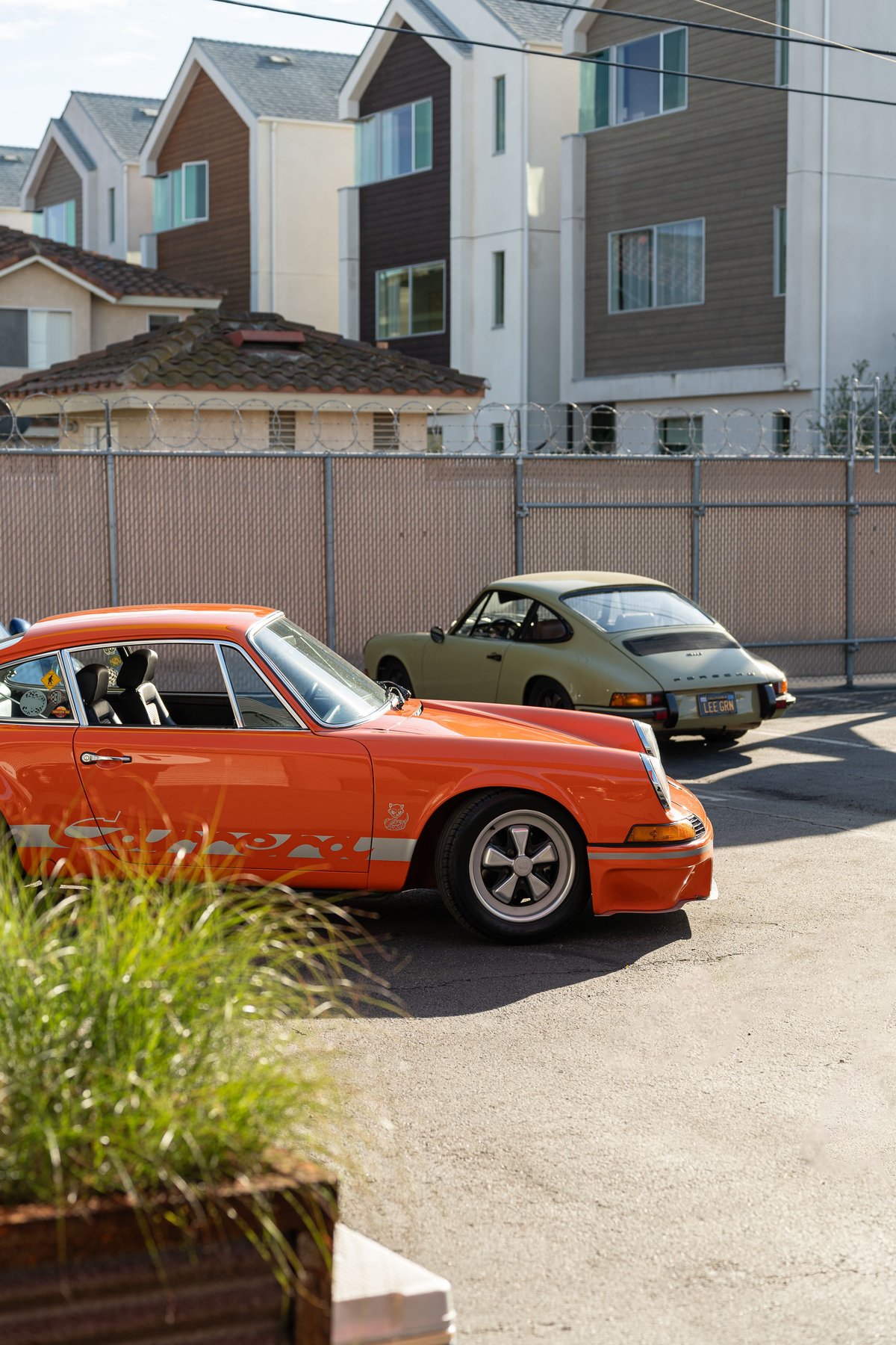 Orange Porsche 911 Carrera with silver livery and Fuchs rims.