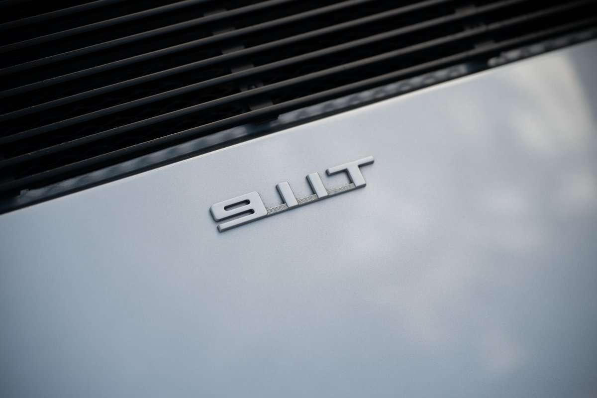 Silver Porsche 911 Turbo emblem on rear decklid.