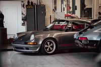 Grey Porsche 911 with red "PORSCHE" livery and Fuchs rims.