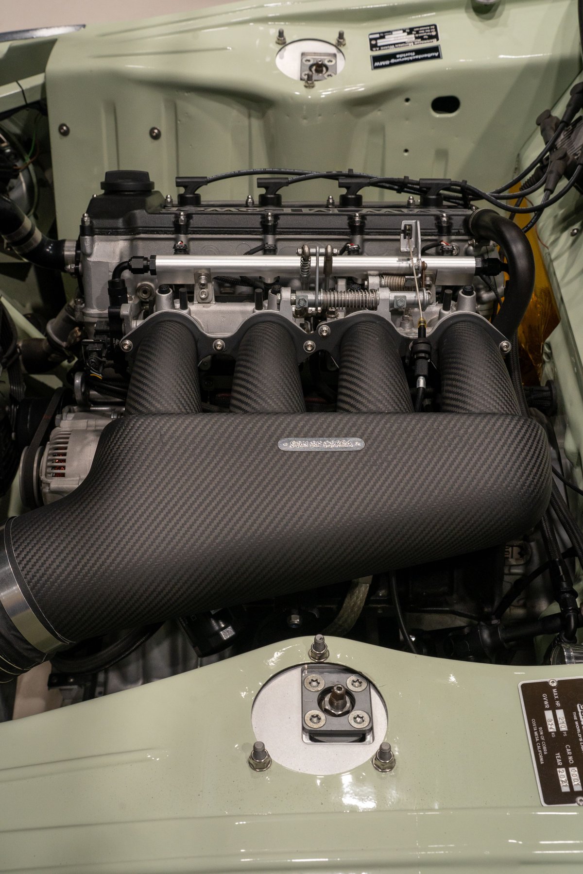 Custom BMW M3 engine bay with carbon fiber intake manifold.