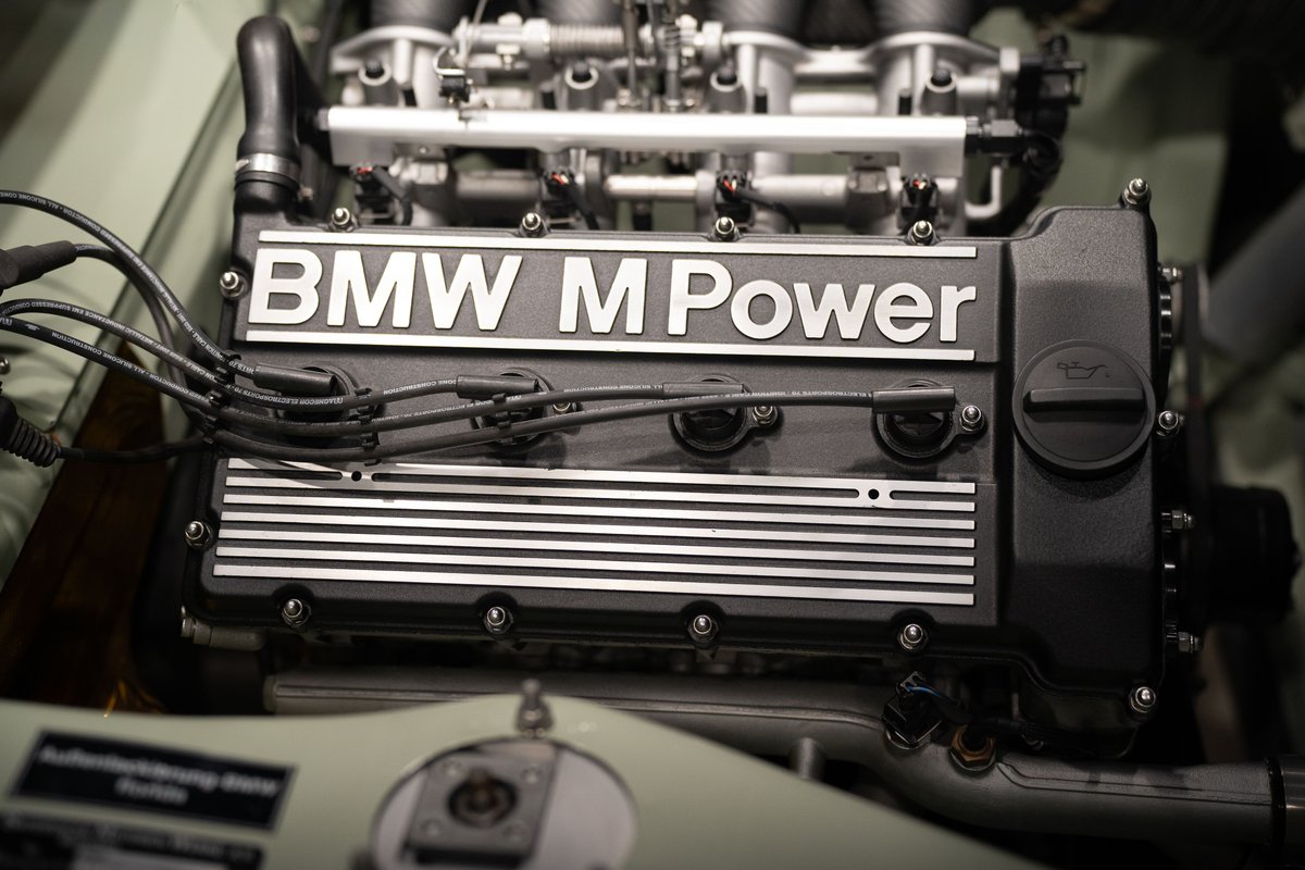 Close-up of a BMW M Power engine, showcasing the iconic engine cover and intake system.