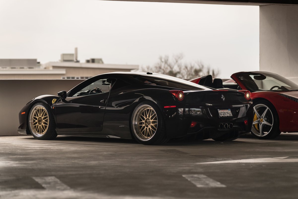 Black Ferrari 458 Italia with gold multi-spoke rims and polished trim.