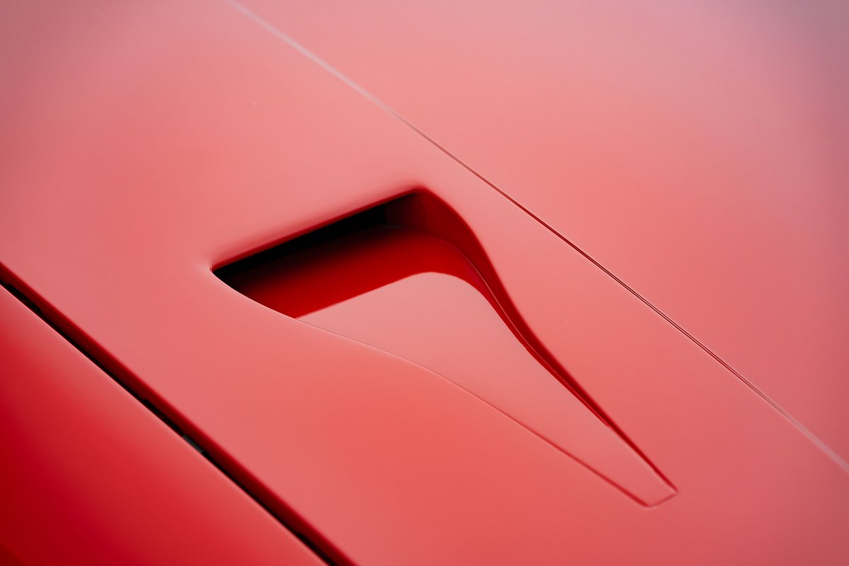 Close up of a red 1981 Porsche 924 Turbo hood vent.