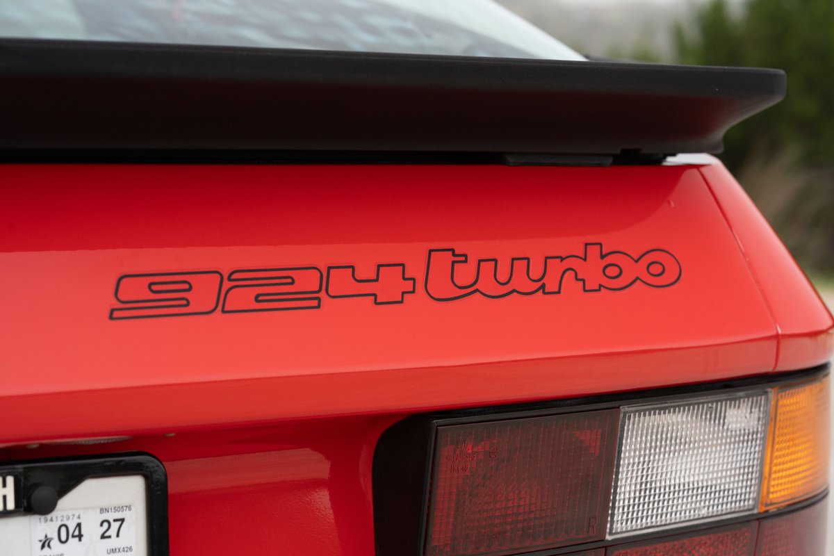 Rear view of a Guards Red 1981 Porsche 924 Turbo with black badging and a black rear spoiler.
