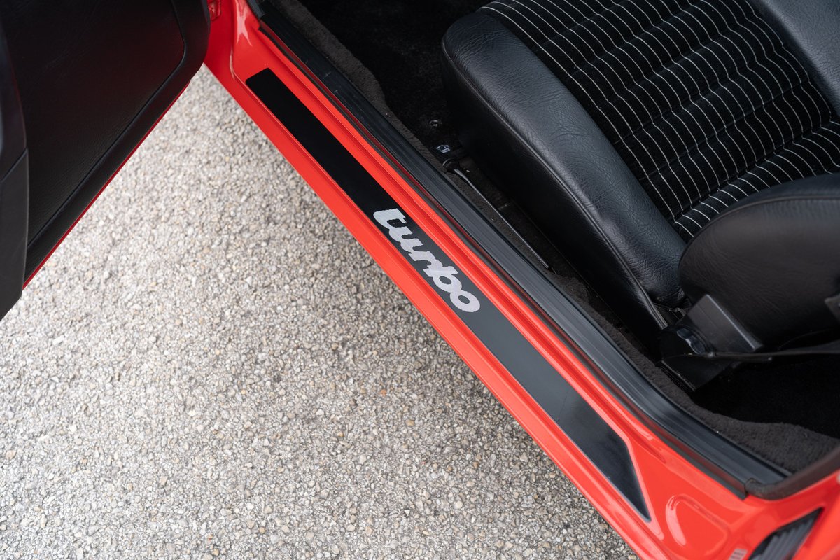 Red 1981 Porsche 924 Turbo door sill trim with "Turbo" lettering.