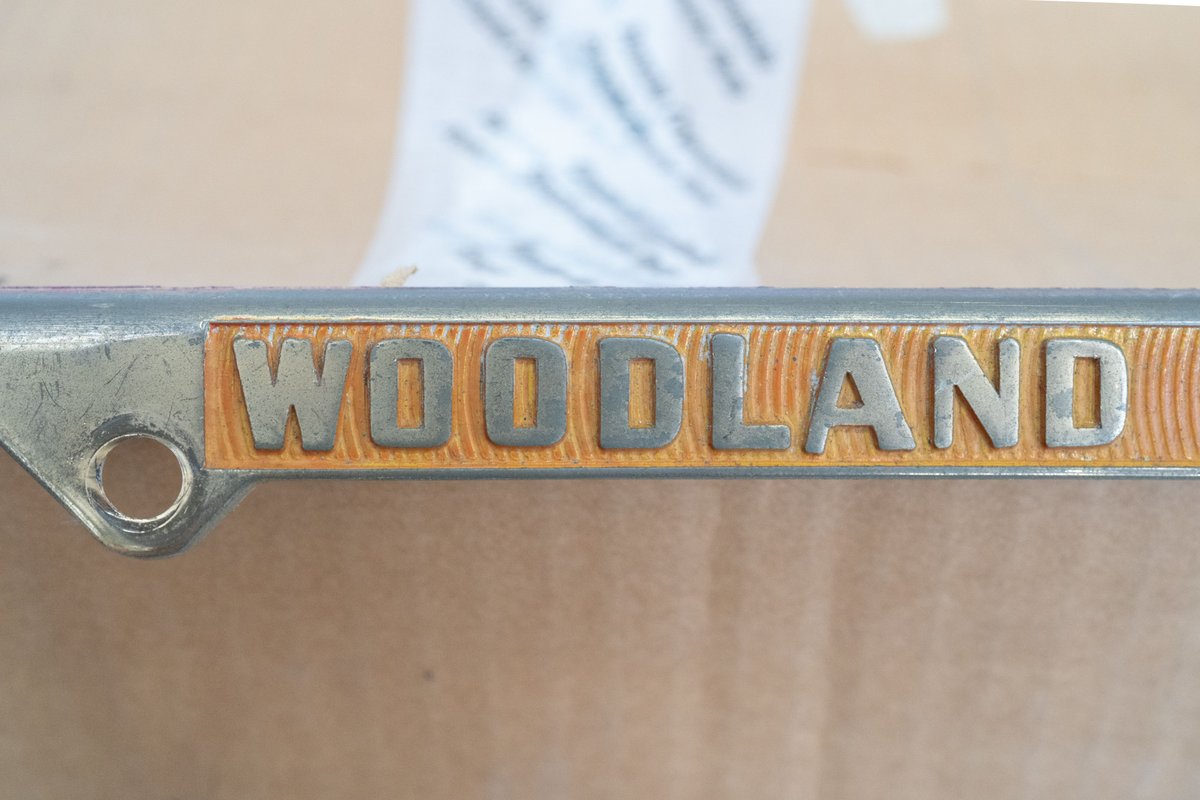 "Woodland" badge on a gold-plated Competition Motors vehicle frame.