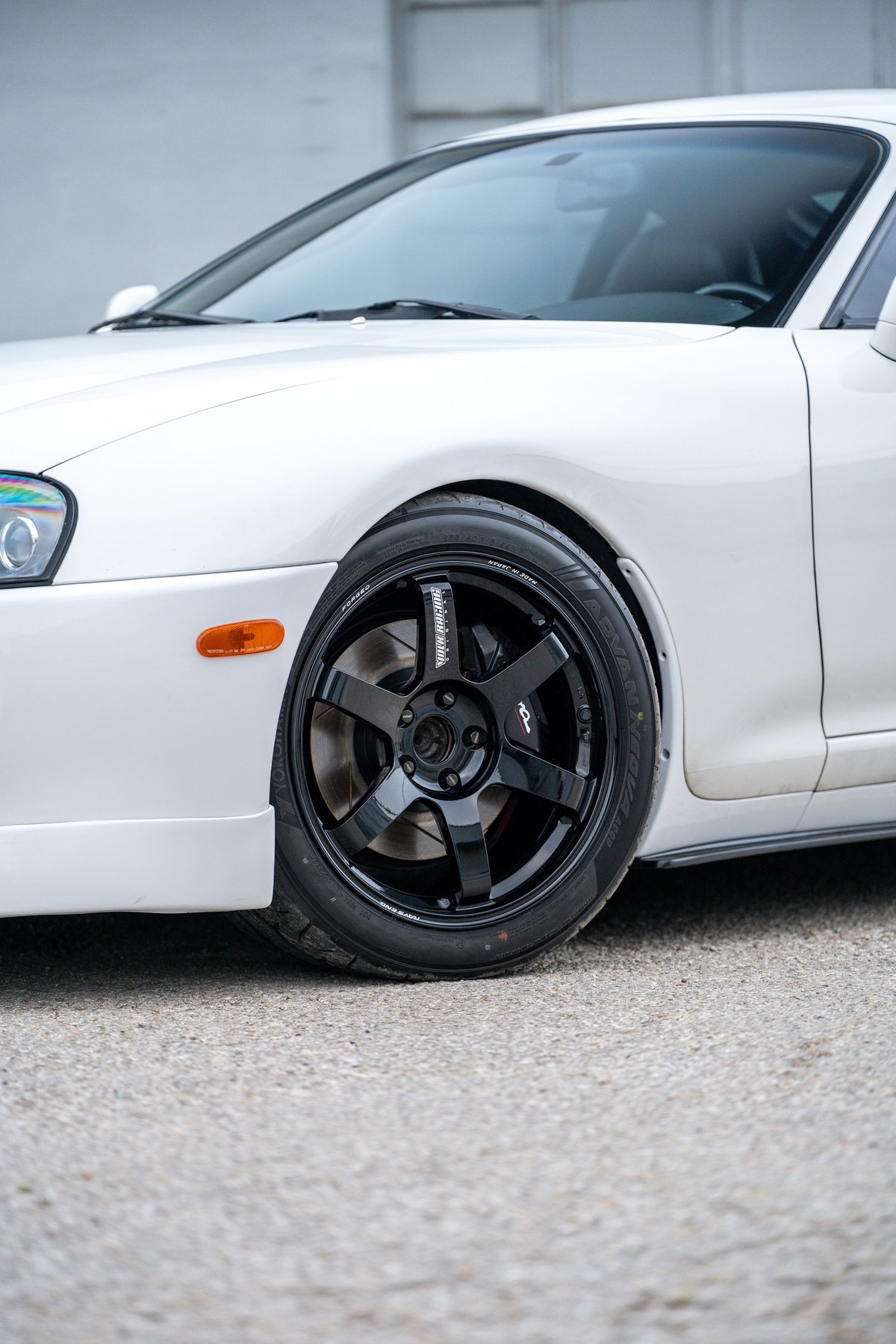 White 1994 Toyota Supra with black 5-spoke TE37 rims and low profile tires.