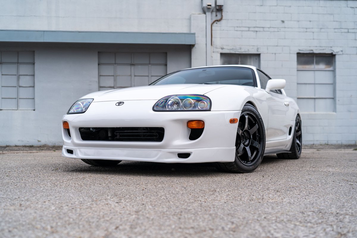 White 1994 Toyota Supra with black rims parked outdoors.