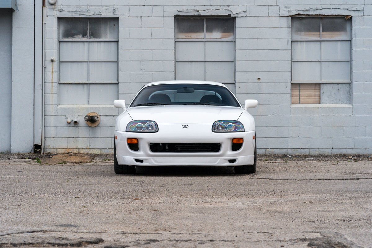 White 1994 Toyota Supra, front view, showing headlights, bumper, and hood.