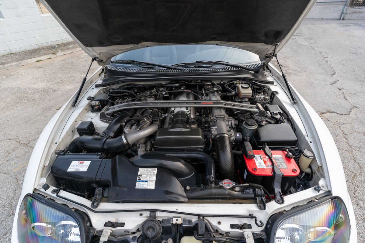 1994 Toyota Supra T56 engine bay, twin-turbo 2JZ-GTE engine, aftermarket intake and strut bar.