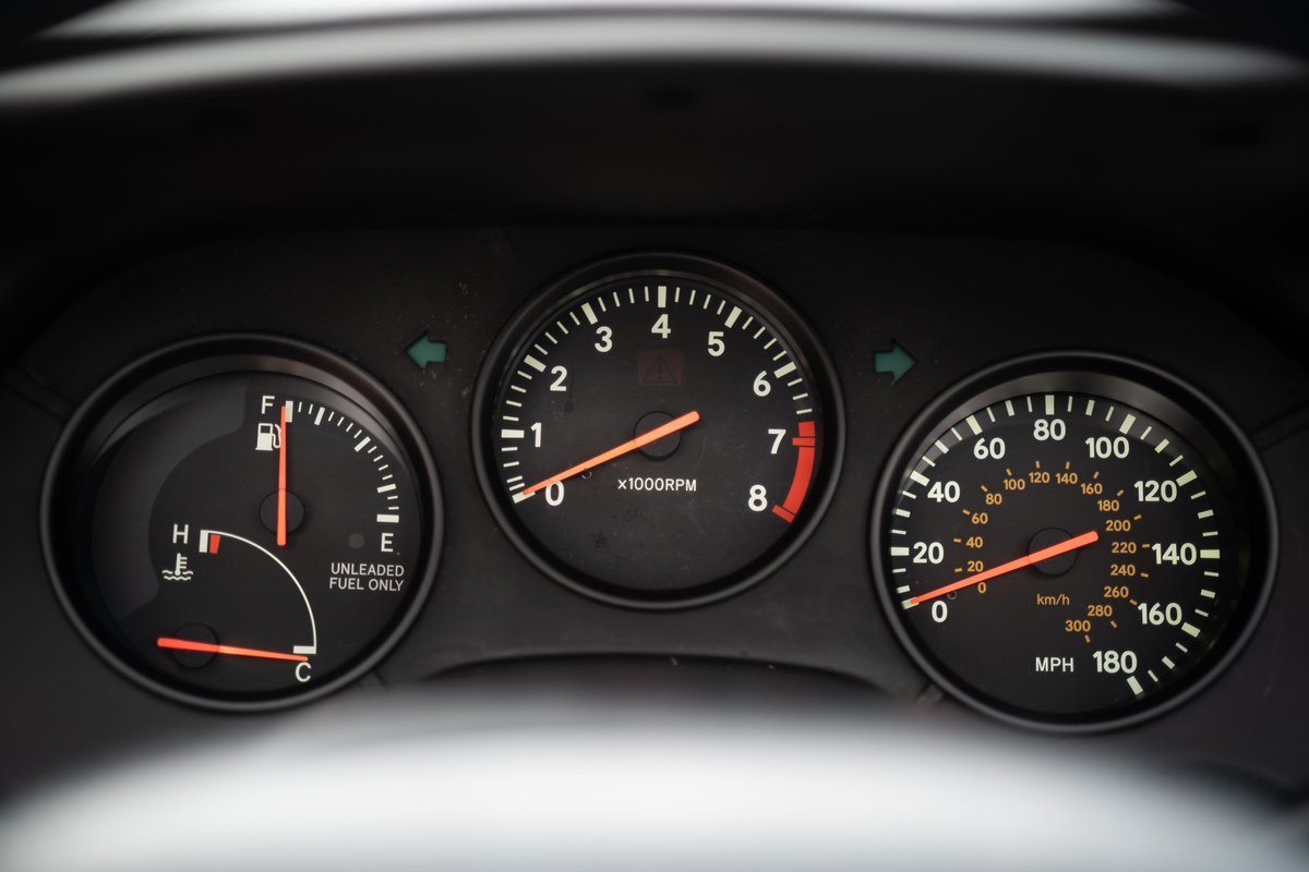 1994 white Toyota Supra dashboard gauges: tachometer, speedometer, fuel, and temp.