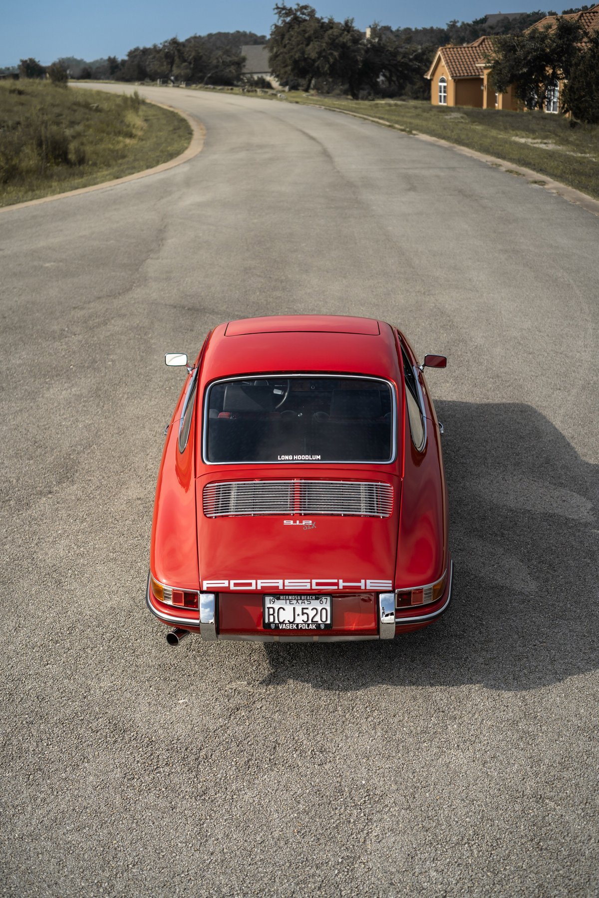 1967 red Porsche 912 Coupe rear view. Chrome trim, exhaust pipe, and license plate visible.