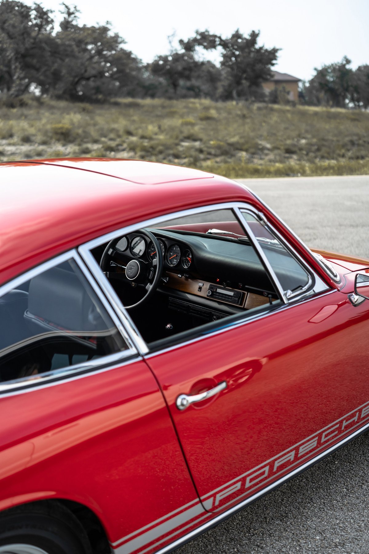 Red 1967 Porsche 912 coupe with side stripe livery and chrome trim.