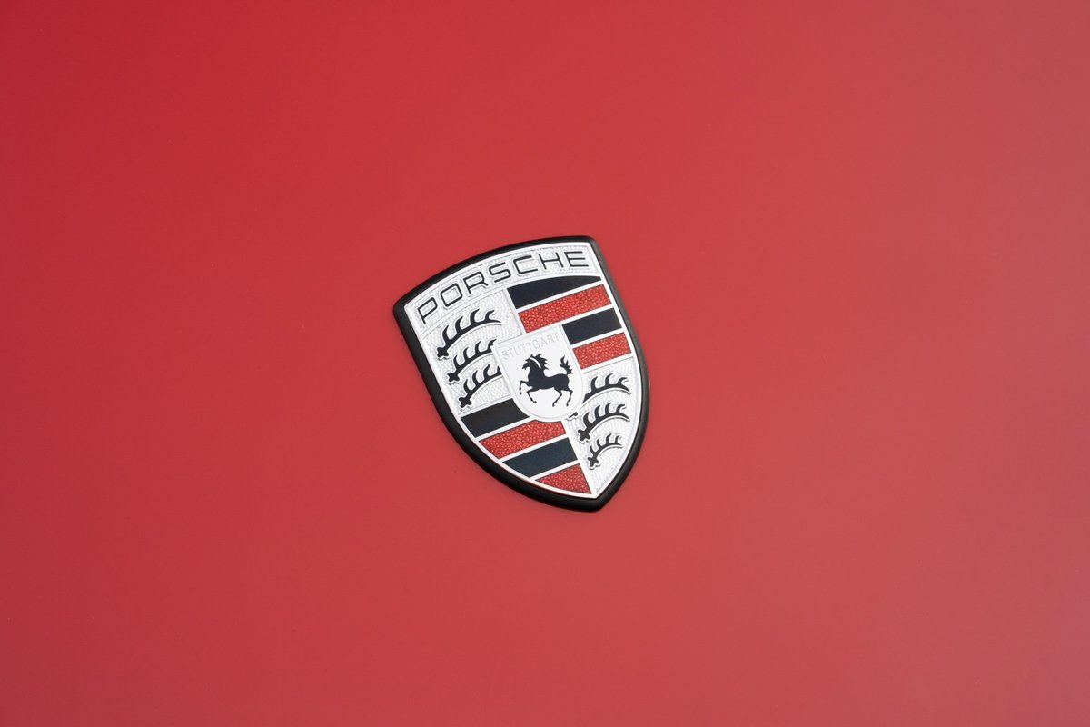 Porsche crest on the red hood of a 1967 Porsche 912 Coupe.