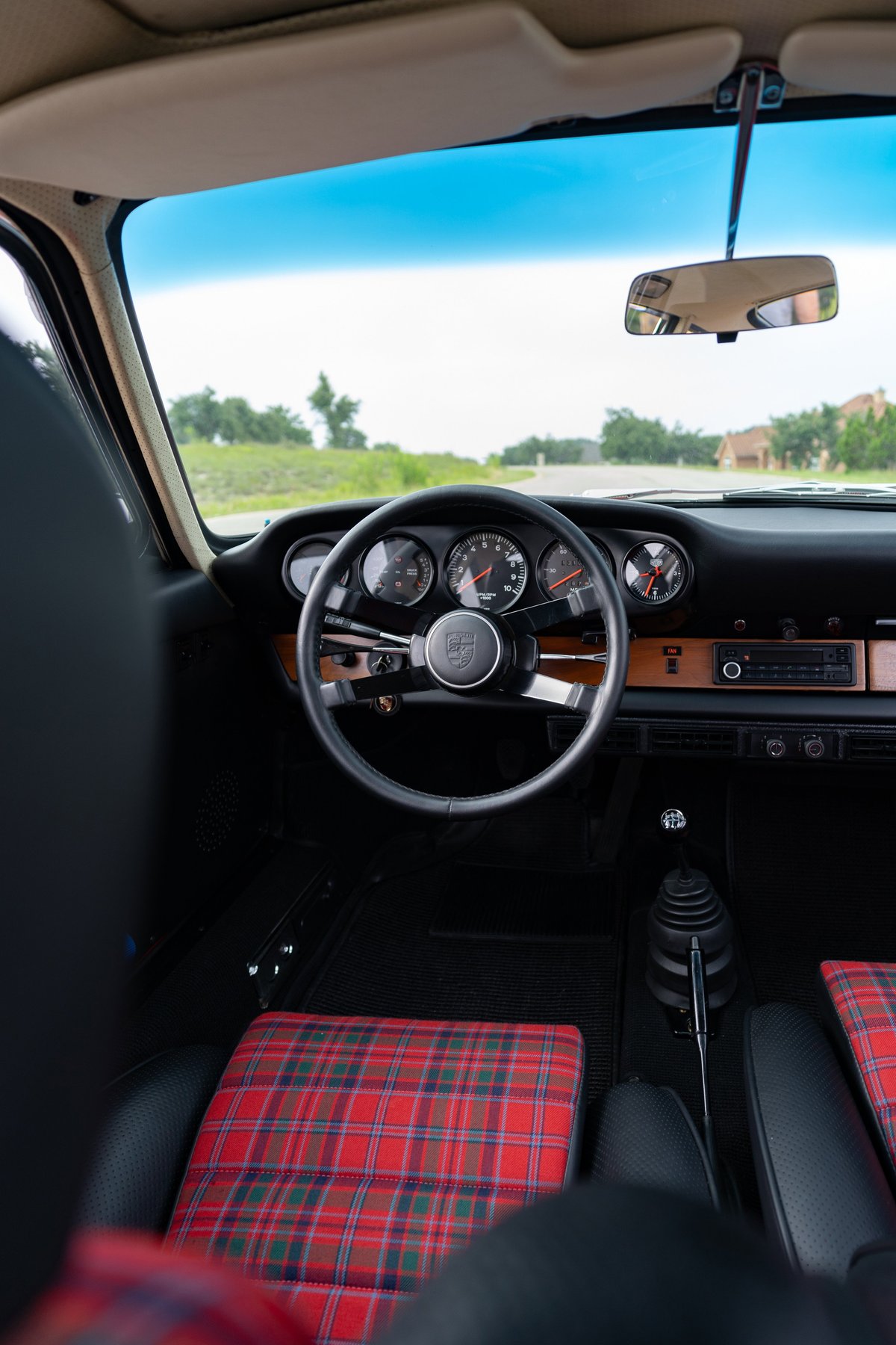 1967 Porsche 912 Coupe interior with tartan upholstery, wood trim, and classic gauges.