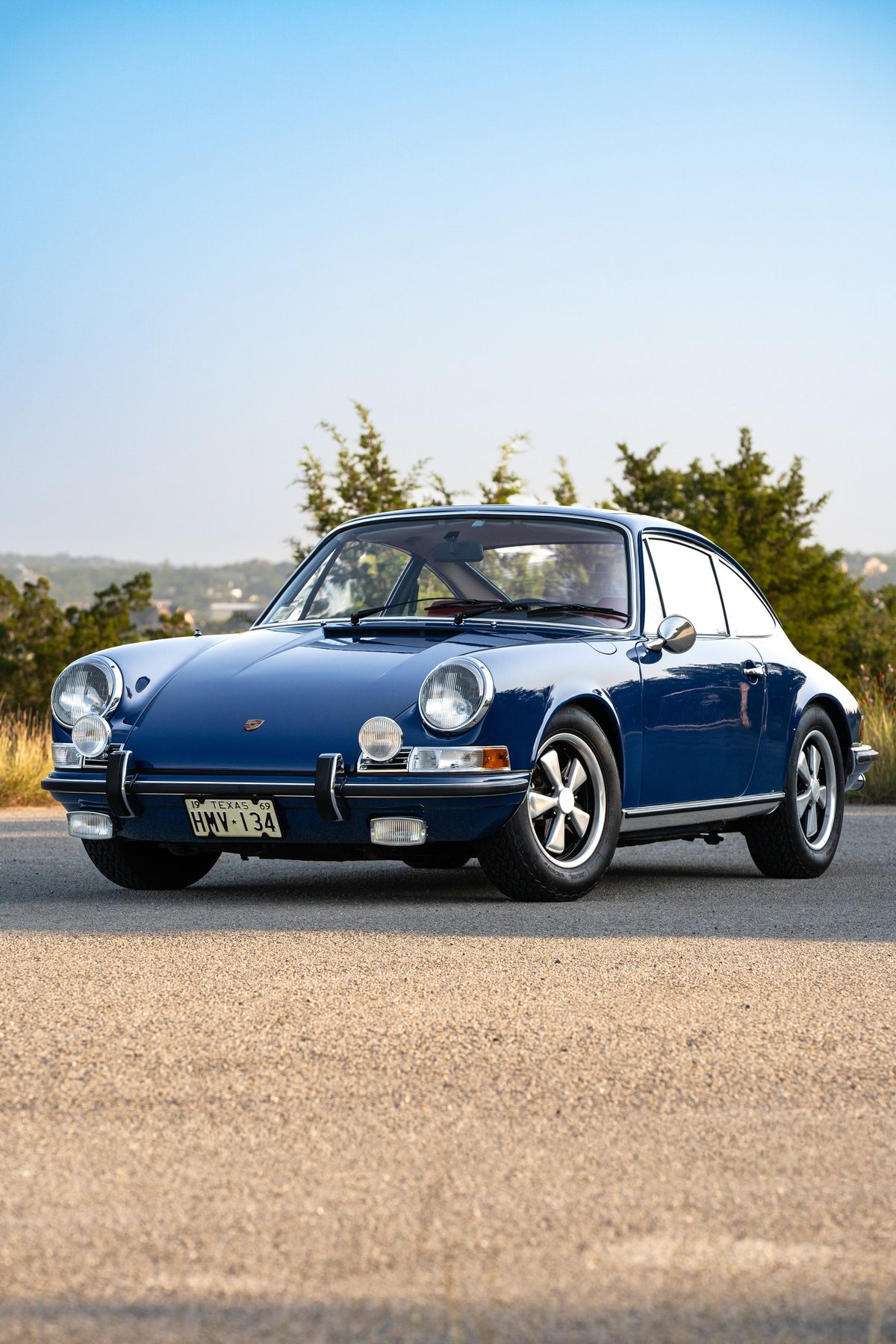 Blue 1969 Porsche 911S coupe with chrome trim and Fuchs rims.