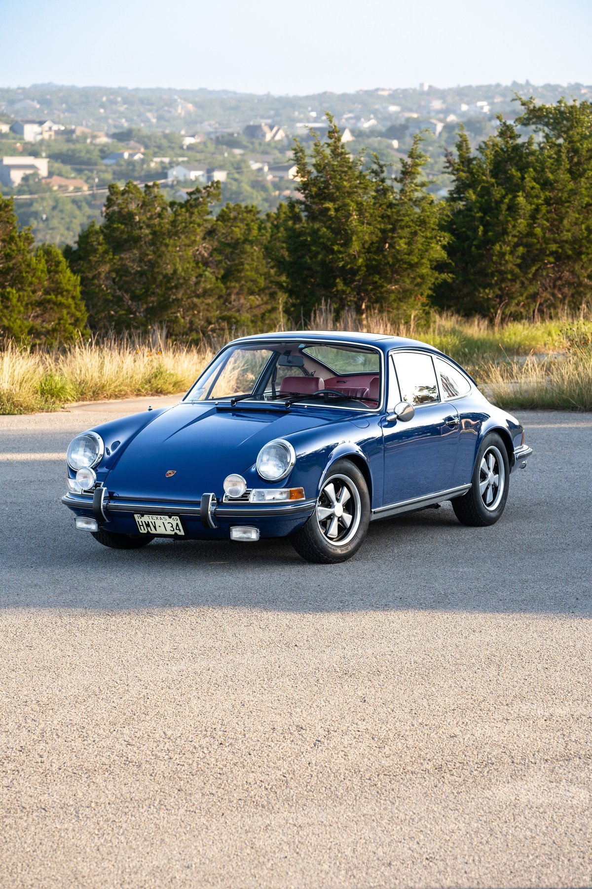 Blue 1969 Porsche 911S coupe with red interior and chrome trim.