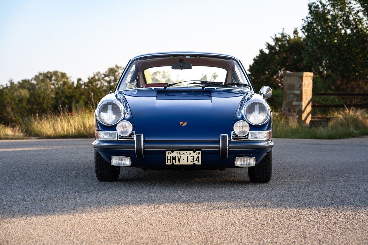 Front view of a blue 1969 Porsche 911S, featuring chrome bumpers and classic rims.