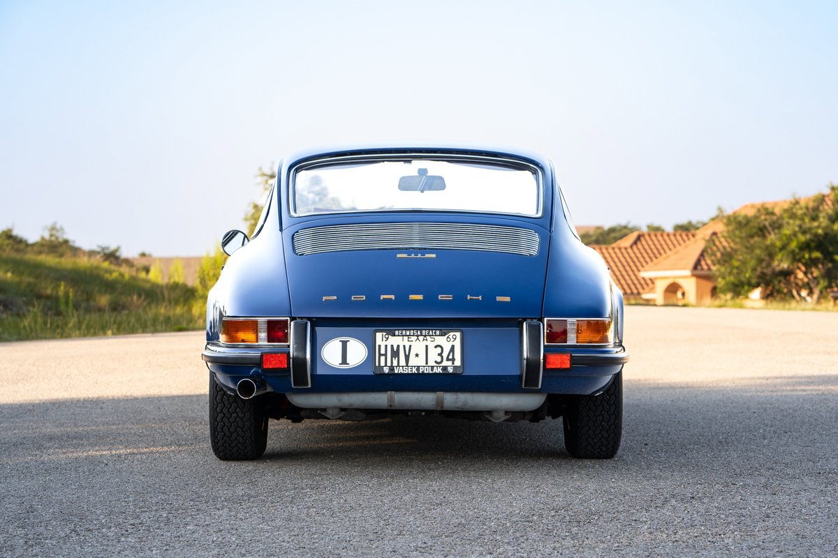 Rear view of a blue 1969 Porsche 911S with chrome trim and Fuchs rims.