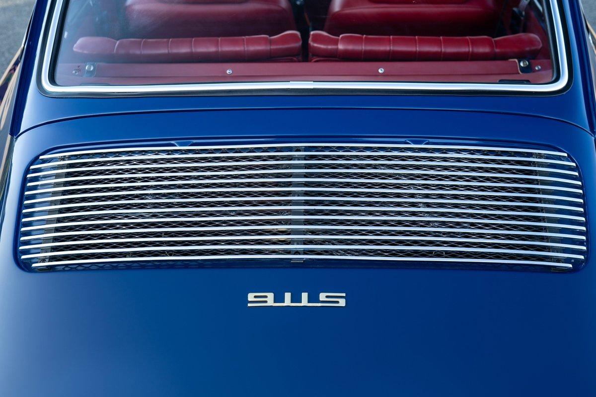 Blue 1969 Porsche 911S convertible with red leather interior and a rear grille.