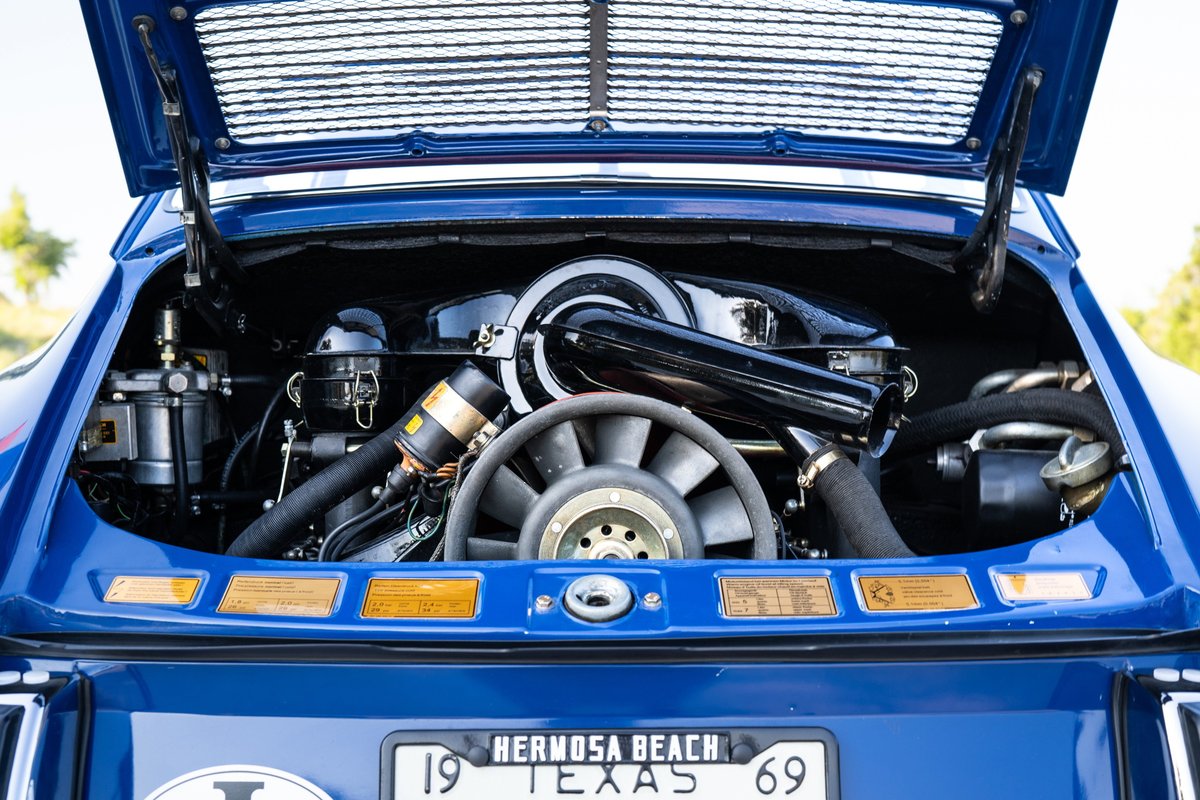 Blue 1969 Porsche 911S engine bay with fan, intake, and exhaust.