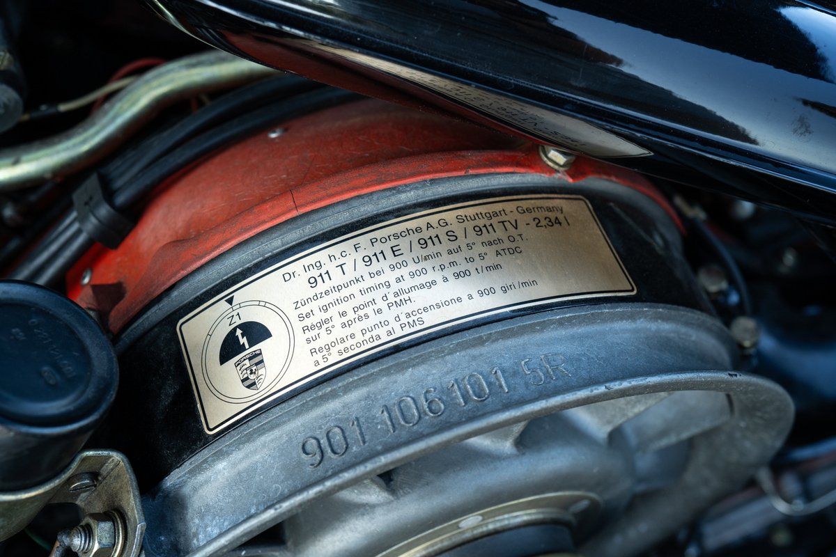 Close-up of a 1969 Porsche 911S engine bay, showing an engine ID plate and fan shroud.