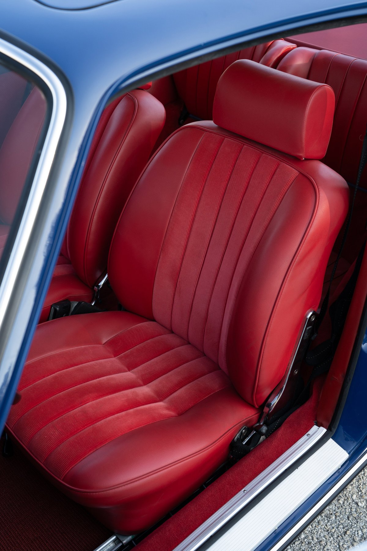 1969 Porsche 911S interior: red leather seats with ribbed inserts, chrome trim, blue exterior paint.
