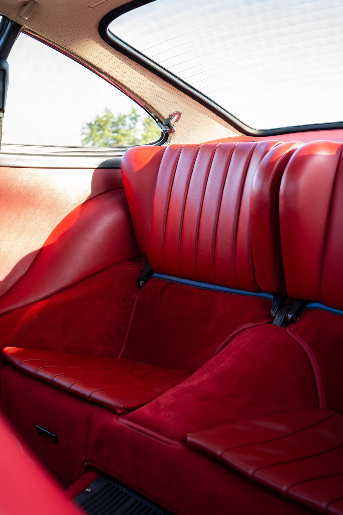 Red leather rear seats and carpeting in a vintage Porsche 911S.