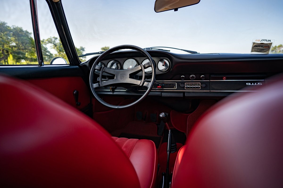 1969 Porsche 911S interior: red leather seats, black dash, classic steering wheel.