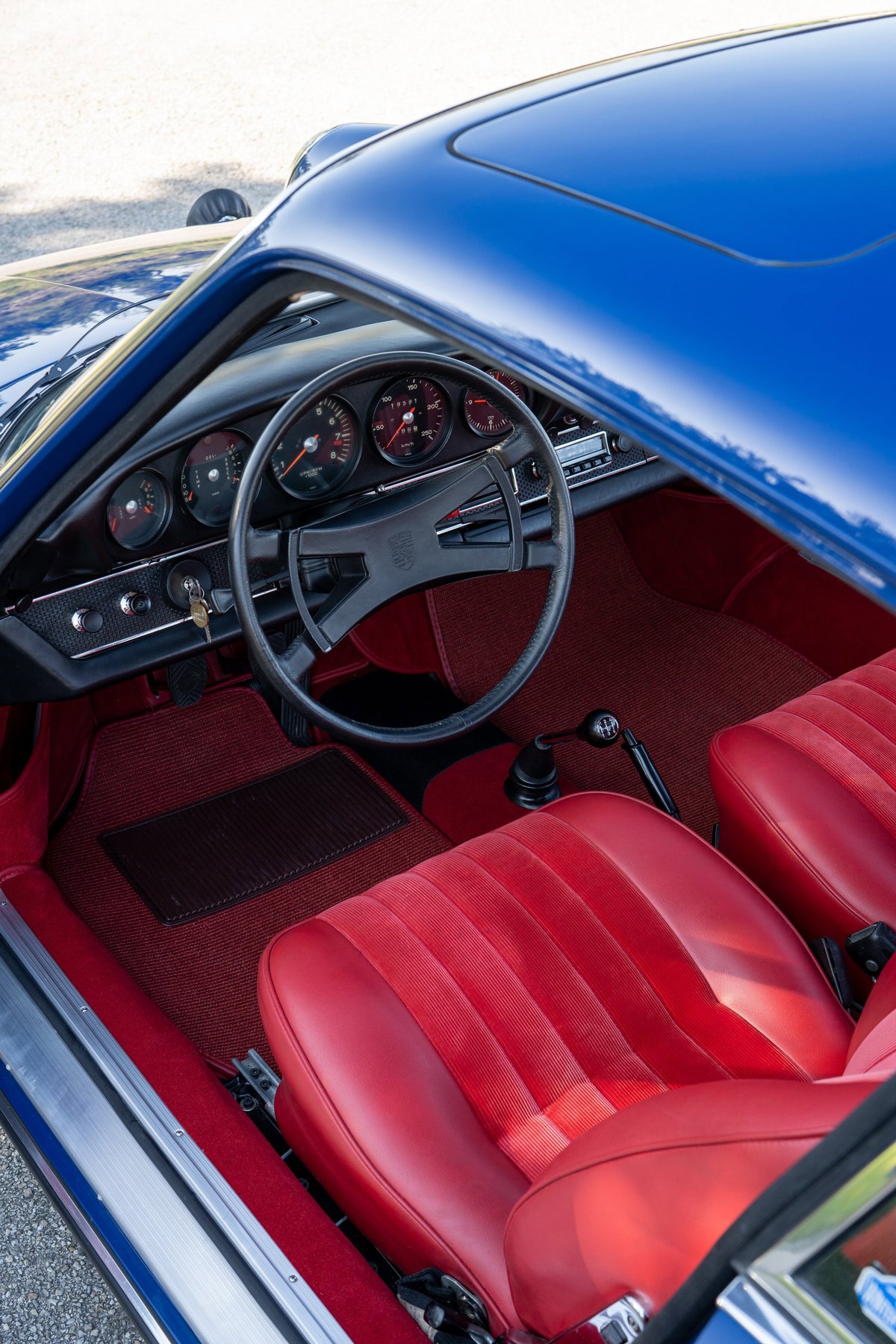 1969 Porsche 911S interior: blue exterior, red leather and corduroy seats, classic gauges.