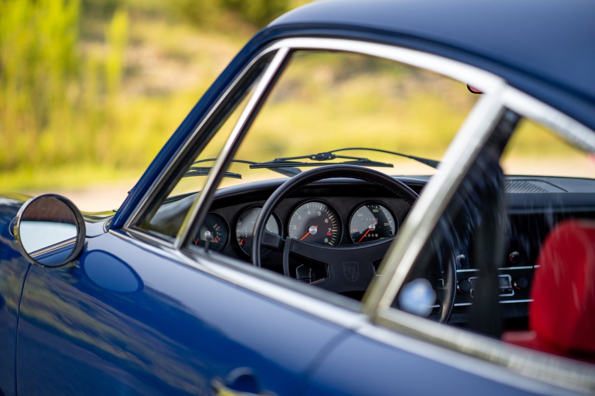 Blue 1969 Porsche 911S interior, with red seats visible through the open door.