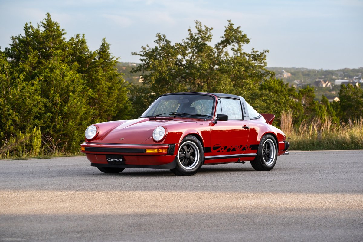 Red 1974 Porsche 911 Carrera Targa with black "Carrera" livery and Fuchs wheels.