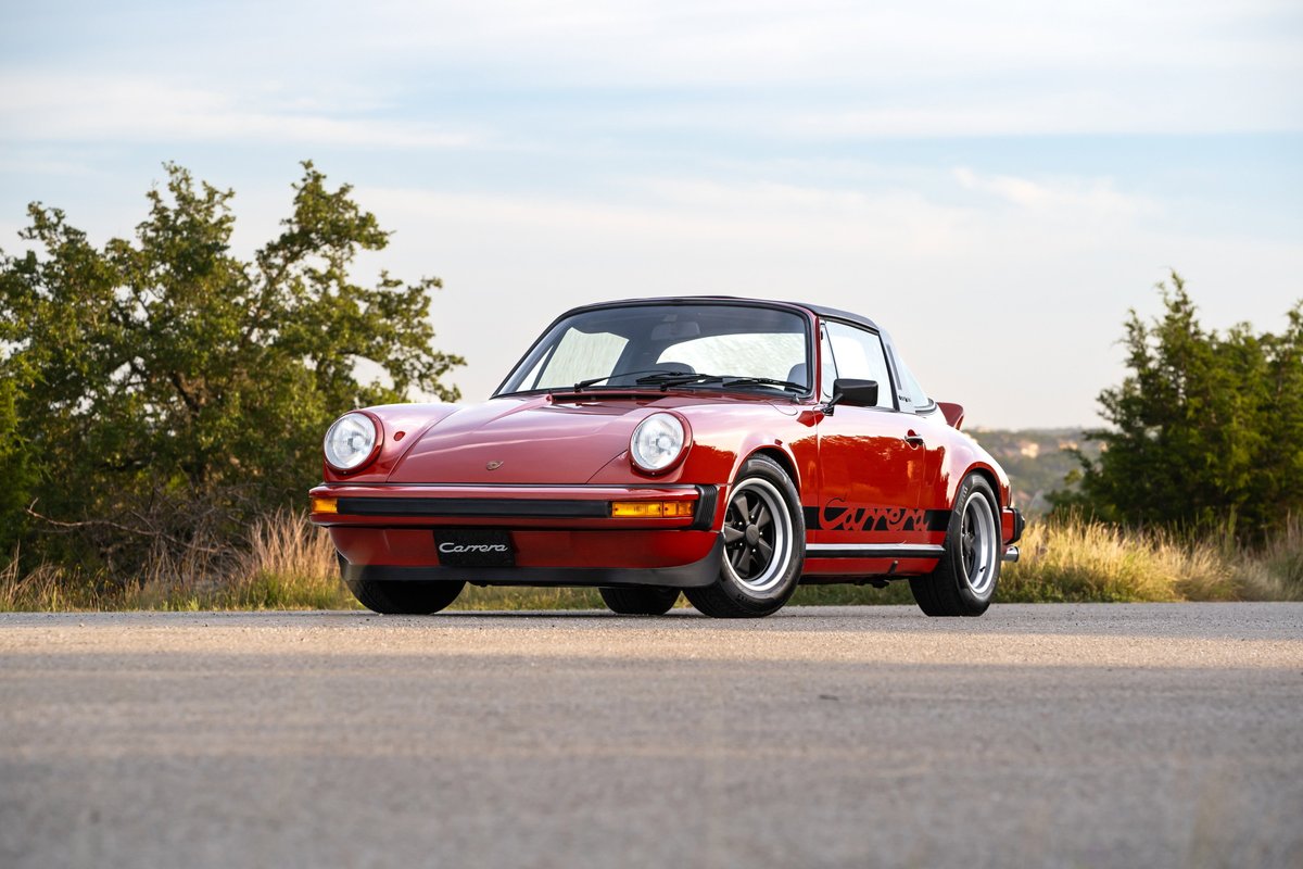 Red 1974 Porsche 911 Carrera Targa with black Carrera side livery and Fuchs wheels.