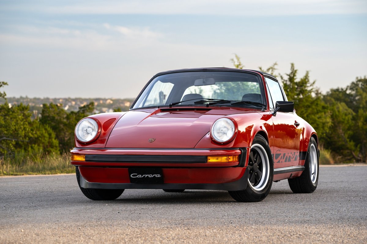Red 1974 Porsche 911 Carrera Targa with black trim and wheels.